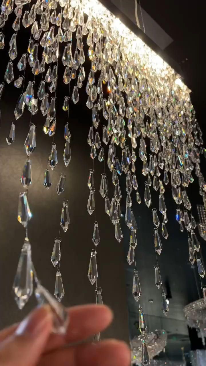 a chandelier hanging from the ceiling with lots of clear crystal drops on it