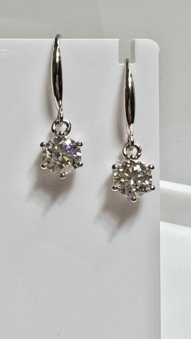 Silver with 14K White Gold Rhodium Brilliant Cut Moissanite Hanging Solitaire Earrings Dangling. 1 Carat Each Moissanites Set in a Solitaire Style with Six Prongs. Moissanite weighs approximately 2.00 Carats in total. 7mm in diameter.   Beautiful clarity and color, amazing brilliance.   Moissanites are alternatives to mined diamonds for those interested in a stones other than diamonds. Certified Moissanite, paperwork included in sale. Diamond Solitaire Earrings, Solitaire Diamond Pendant, Diamond Pendants Designs, Solitaire Earrings, Garnet Earrings, Solitaire Pendant, Hanging Earrings, Pendant Design, 1 Carat