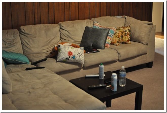 a living room with couches and pillows on the floor