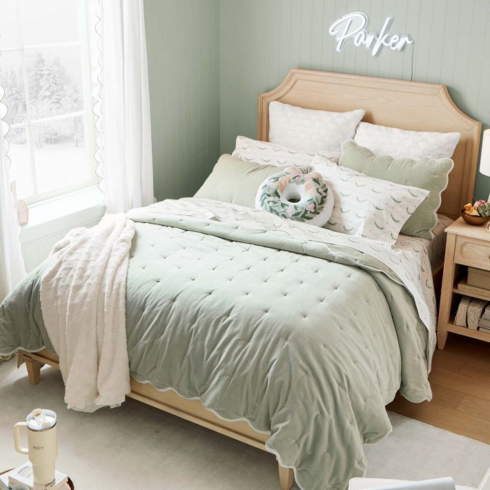 a bedroom with green walls and white bedding