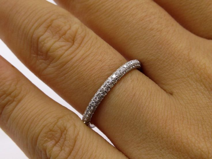 a woman's hand with a wedding ring on it, showing the diamond band