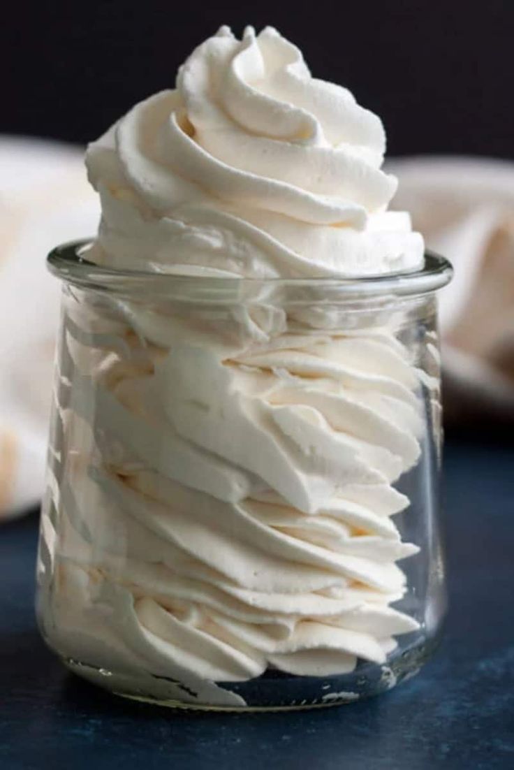 a glass jar filled with whipped cream on top of a table