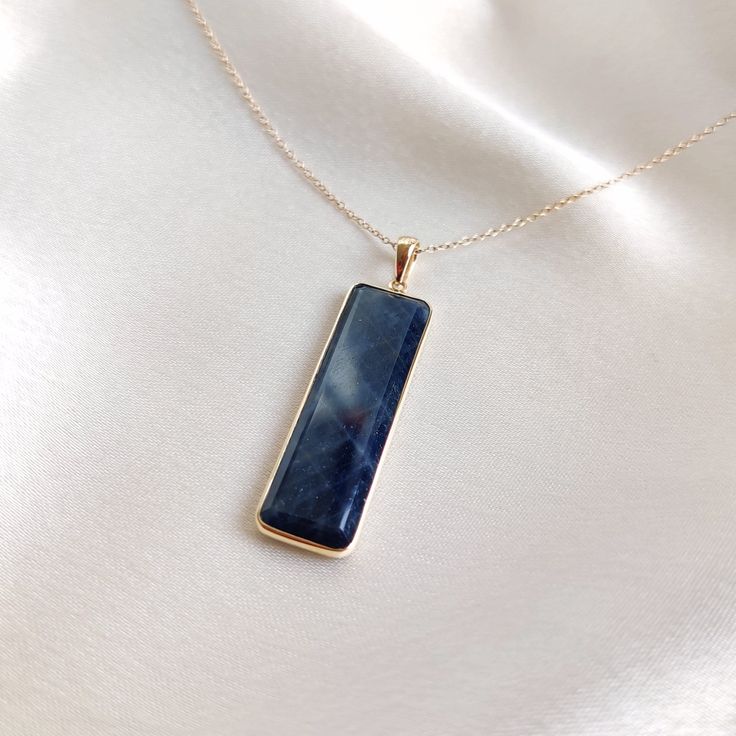 This stunning pendant is set in 14k Solid Yellow Gold with Natural Blue Sapphire with utmost precision. It is a unique gemstone Pendant for nearly every occasion and is completely hassle-free jewelry. ITEM DETAILS: * Gem: Blue Sapphire * Gem Size: 10X35mm * Gem Shape: Rectangle * Gem Weight: 19.79 carats * Gold Purity: 14KT  * Gold Weight: 0.81 gram * Total Weight of the Pendant: 4.77 gram The Gold purity is guaranteed and it comes with authentic 14KT gold hallmark. Since my items are handmade, they are absolutely nickel and lead free. CUSTOMIZATION: * Gemstone customization is available and it can be substituted with a gem of your choice. Kindly message me for the same. PACKAGING * The Pendant comes with layers of safe and secure wrapping along with Free handmade jewelry box with every pu Blue Rectangular Necklace For Anniversary, Rectangular Blue Sapphire Jewelry, Blue Rectangular Pendant Jewelry For Anniversary, Blue Rectangular Pendant Fine Jewelry, Blue Rectangular Pendant Jewelry For Formal Occasions, Sapphire Gemstone Rectangular Necklace, Sapphire Gemstone Necklace In Rectangular Shape, Rectangular Sapphire Gemstone Necklace, Blue Gemstone Jewelry With Rectangular Pendant