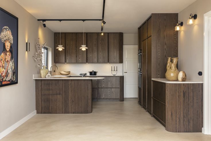 a large kitchen with wooden cabinets and white counter tops, along with an art piece on the wall