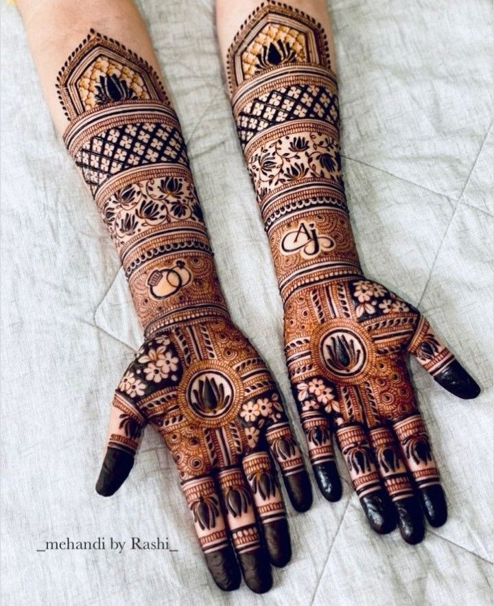 two hands with henna tattoos on them, one is showing the intricate design and the other has geometric designs