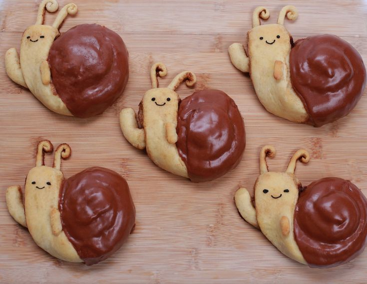 some cookies with chocolate frosting and snails on them