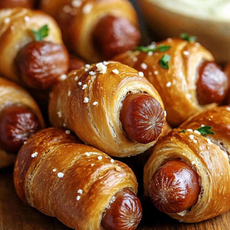 several hot dogs wrapped in bread on a wooden table