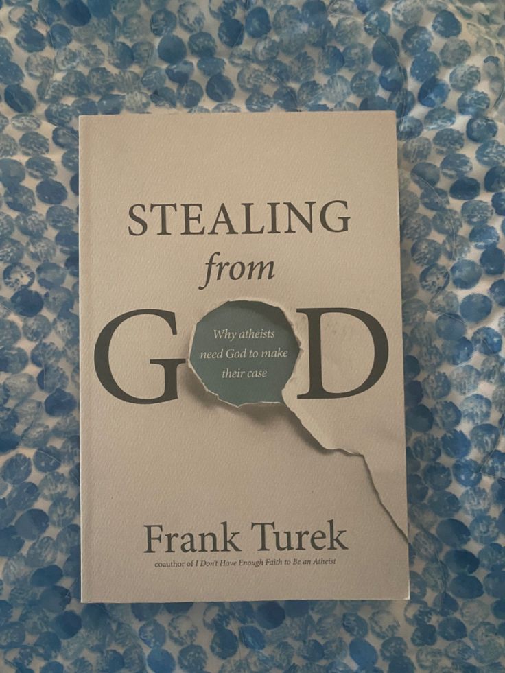 a book that is laying on top of a blue and white table cloth with the title stealing from god