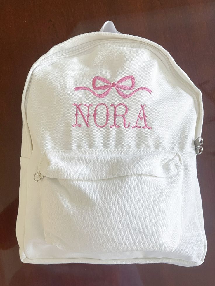 Baby Girl's First Bookbag! Name and thread color are customizable. White canvas book bag. Cute Pink Canvas Bag For School, White Canvas School Bag, Pink Cotton Standard Backpack, Cute Bags With Letter Embroidery For Everyday Use, White School Bags With Letter Embroidery, Cute Bag With Letter Embroidery, Cute Letter Embroidery Bag, Pink Cotton School Bag, Pink School Bags With Letter Embroidery