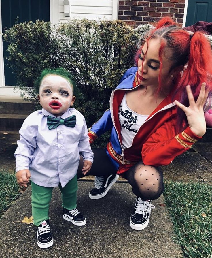 a woman and child dressed up as clowns outside in front of a house for halloween