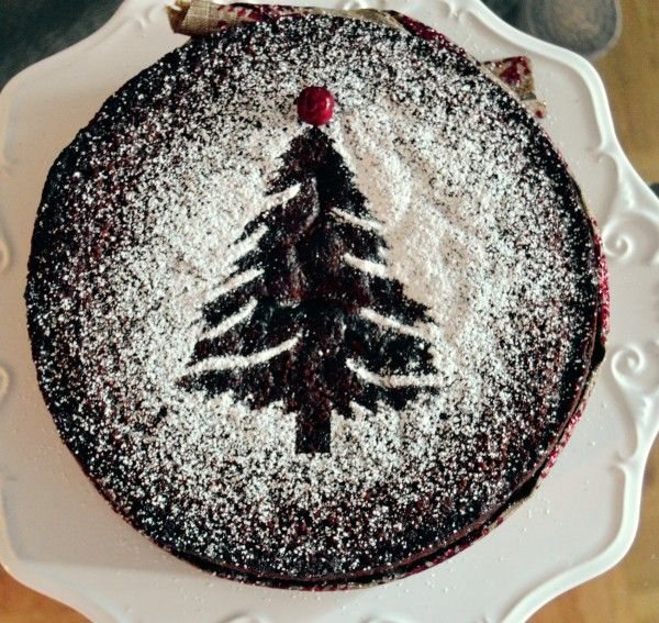 there is a cake that has been decorated with a christmas tree on it and powdered sugar