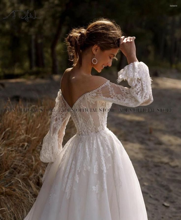 a woman in a white wedding dress standing on the ground with her hands behind her head