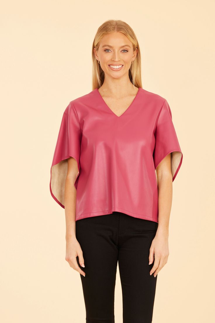 Our Faux Leather Cascade Sleeve Top is sure to be a striking addition to your autumn wardrobe. This versatile and stylish blouse features dramatic cascade sleeves that flow beautifully, adding movement and flair to your look. The sleek faux leather finish offers a modern edge, making it the perfect piece to complete your chic seasonal outfits. Faux leather Cascading sleeves V-neck Available in Black, Dark Pink, and Green Dry clean Style: 75634 Elegant Faux Leather Top For Party, Chic Faux Wrap Fall Blouse, Chic Faux Wrap Blouse For Fall, Elegant Leather Tops For Night Out, Trendy Leather Tops For Spring, Faux Leather Tops For Work In Spring, Faux Leather Top For Work In Spring, Faux Leather Tops For Spring Workwear, Elegant Leather Tops For Fall