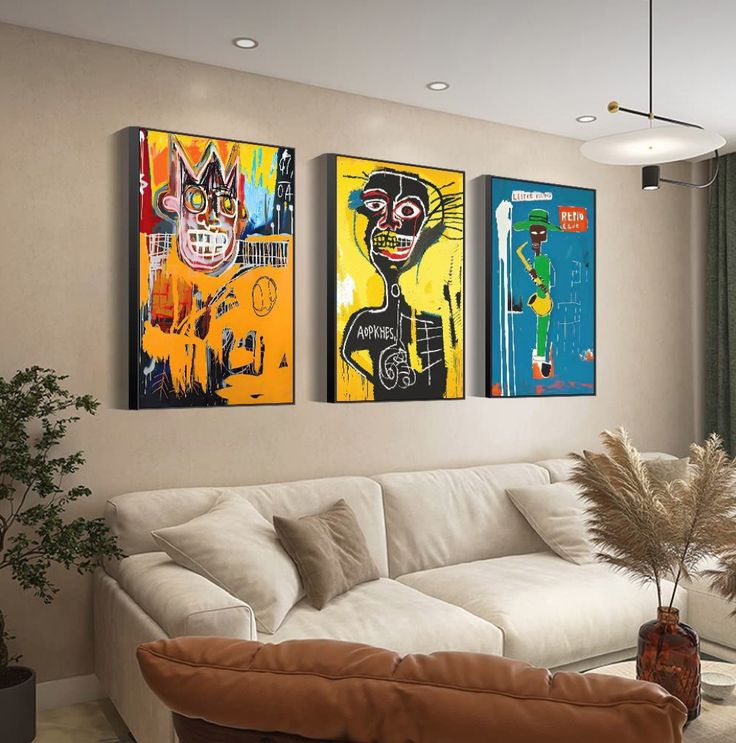 a living room with three paintings on the wall