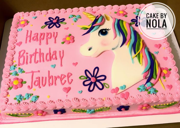 a pink birthday cake with a unicorn on it