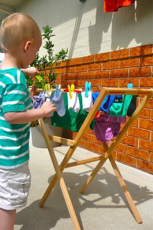 a little boy that is standing in front of a clothes line