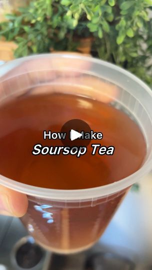 someone holding up a plastic cup filled with tea and the words how to make sourop tea