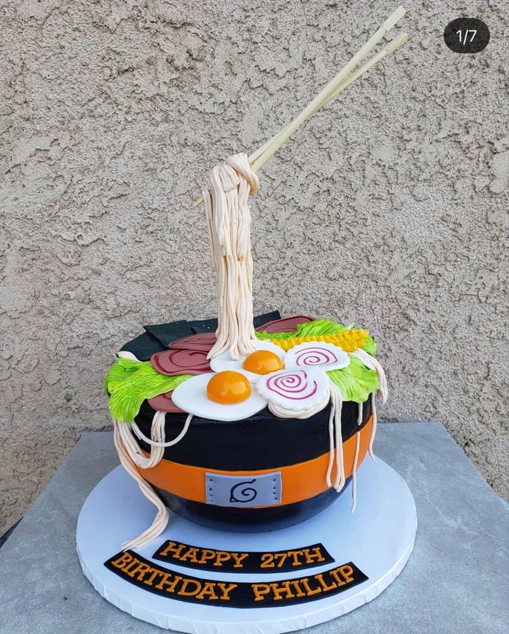 a birthday cake made to look like a bowl of food with chopsticks sticking out of it