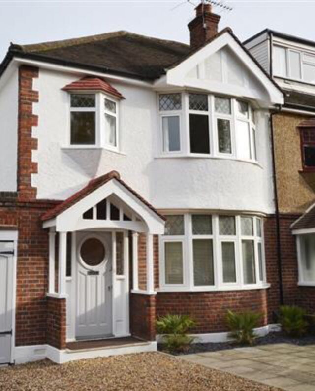 a large white house with lots of windows and brickwork on the front of it