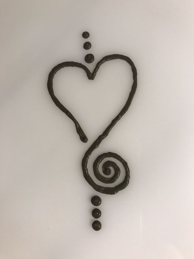 a heart shaped object with spirals and dots in the middle on a white background