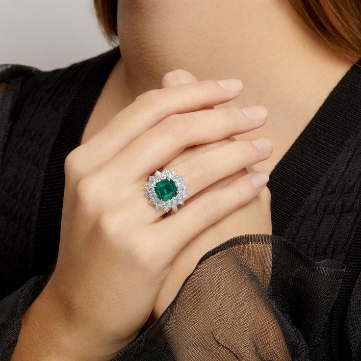 One of a Kind Ring. Outer diameter of ring measures 22mm x 22mm. Center stone Emerald measures 10mm x 10mm. Emerald sourced from Zambia. SKU ASRW4237 Carat Weight 4.72ct Emerald || 4.27ct Diamond Metal Type 18KT White Gold Primary Stone Emerald Weight 6.57g Color Grade H Clarity VS Luxury Gia Certified Diamond Gemstones, Luxury White Gold Gia Certified Gemstones, Luxury Gia Certified White Gold Gemstones, Luxury Gia Certified Emerald Gemstones, Luxury Gia Certified Gemstones, Luxury Diamond Cluster Ring With Gemstones, Luxury Cluster Ring With Round Cut Gemstone, Luxury Cluster Diamond Ring With Gemstone, Luxury Round Cut Gemstones With Center Stone