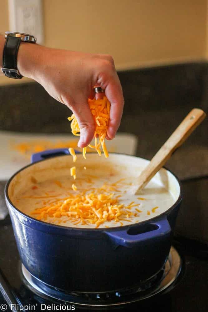 a person scooping cheese out of a pot on the stove