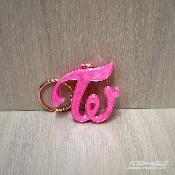 a pink keychain with the letter t on it