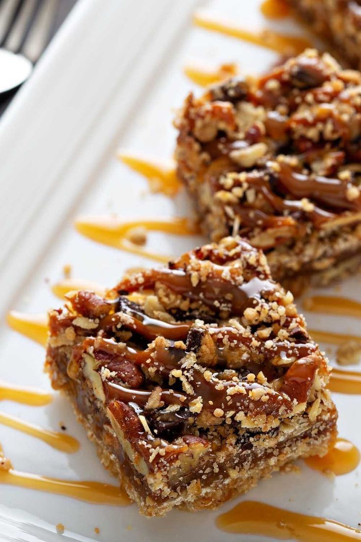 three pieces of dessert sitting on top of a white plate with caramel drizzle