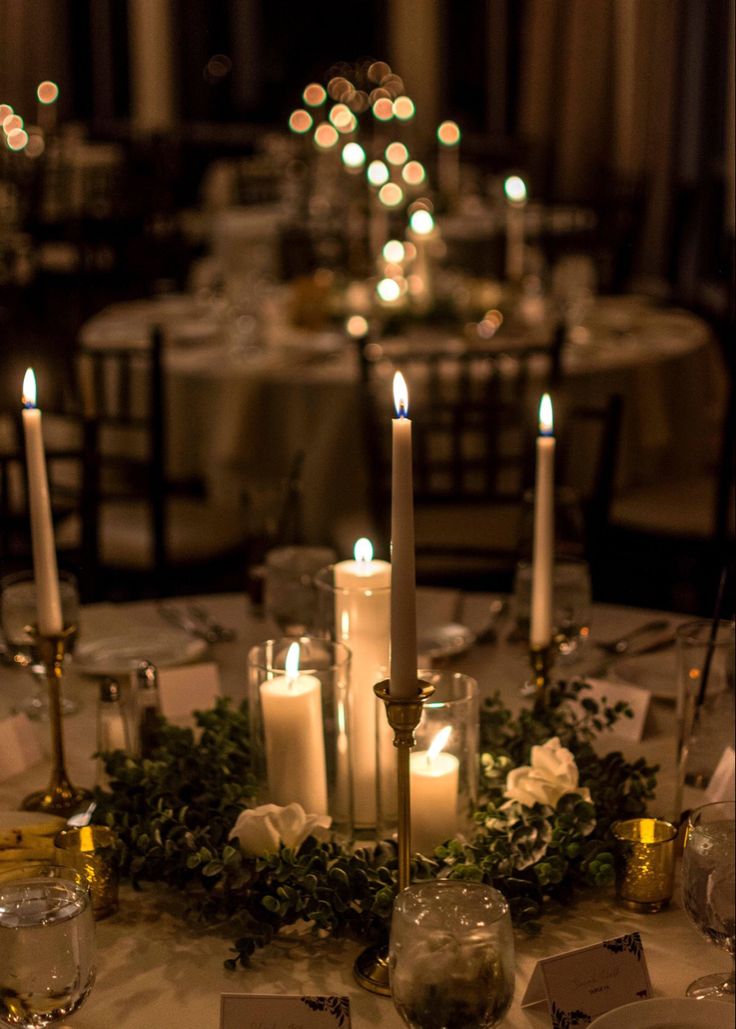 the table is set with candles and place cards