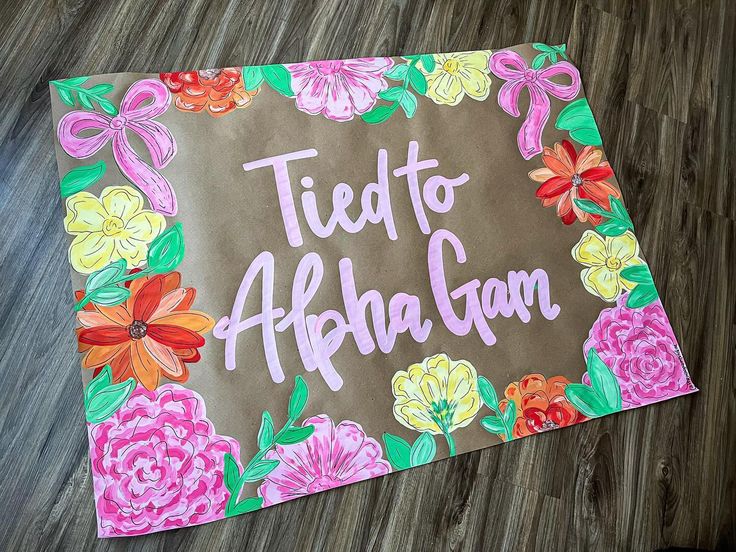 a hand painted sign that says tied to abraham with flowers and leaves around it on a wood floor