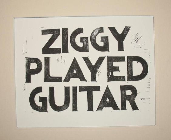 a sign that says ziggy played guitar in black on a white paper background