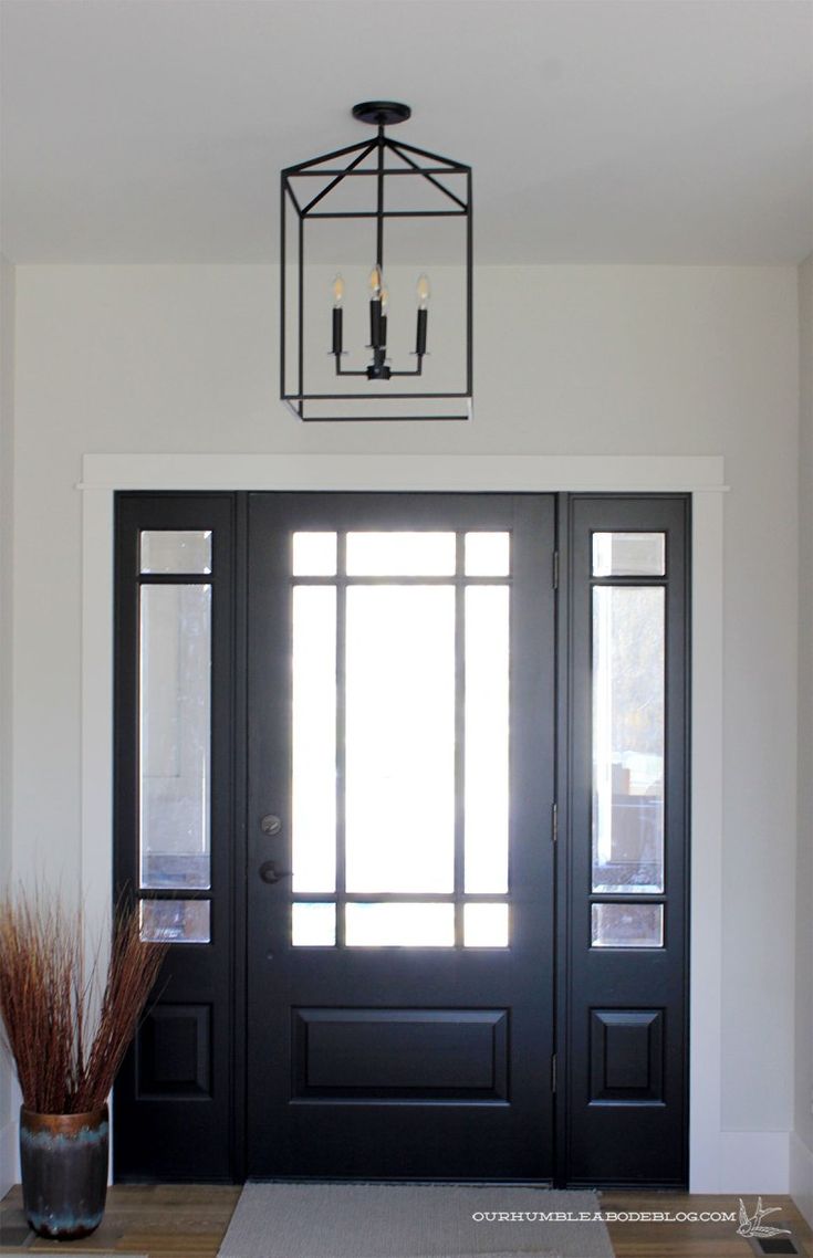 a black front door with two glass panels and a light fixture above the entryway