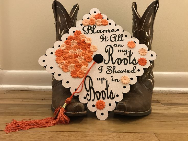 a pair of cowboy boots with flowers on them and a tassel hanging from the boot