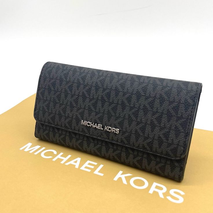 Brand New With Tag Michael Kors Jet Set Travel Item Trifold Wallet Saffiano Leather Color: Black Silver Tone Hardware Michael Kors Lettering Logo On Front Trifold Wallet W/ Snap Button Closure Full Length Zippered Pocket W/ Leather Pull On Back Interior: 1 Window Id, 4 Full Bill Slots, & 17 Credit Card Slots. Mk Signature Logo Fabric And Saffiano Leather Lining 7.5" W X 4" H X 0.75" D Black Trifold Wallet For Evening, Elegant Gray Wallets For Formal Occasions, Elegant Evening Wallets By Michael Kors, Modern Trifold Wallet For Evening, Modern Evening Trifold Wallet, Elegant Everyday Wallets With Logo, Elegant Wallets With Logo, Elegant Michael Kors Evening Wallets, Elegant Evening Michael Kors Wallets