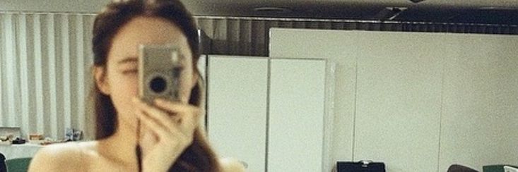 a woman taking a selfie in front of a mirror