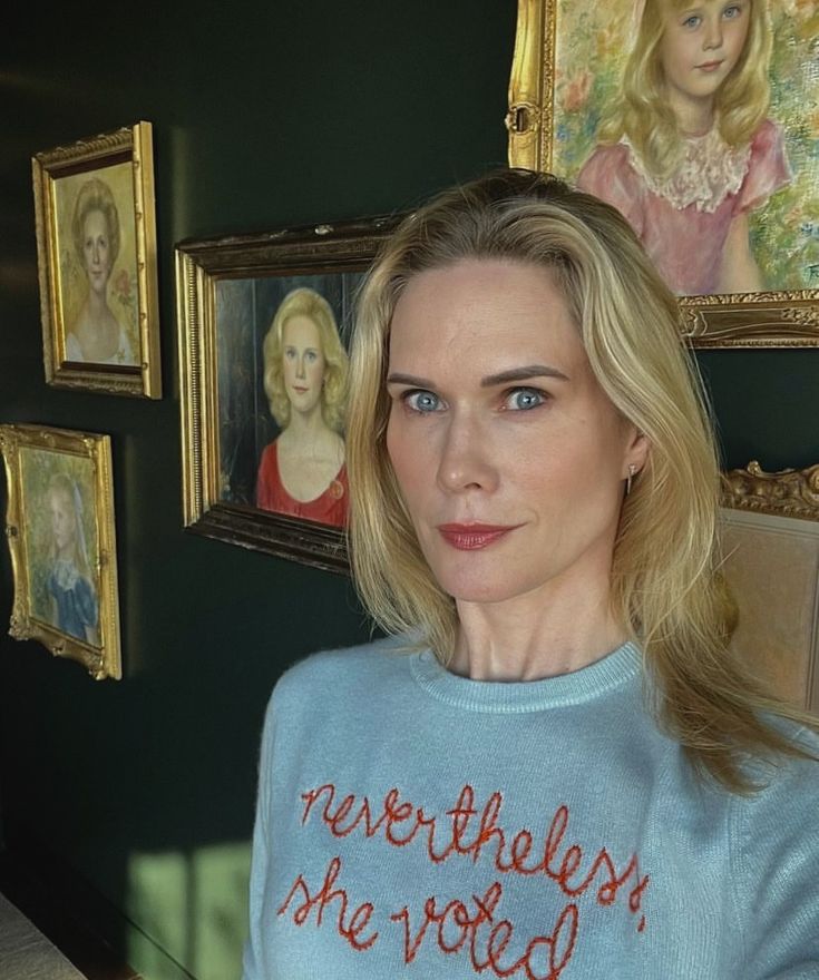 a woman with blonde hair wearing a blue sweater