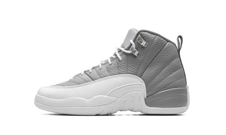 The Air Jordan 12 GS “Stealth” is the youth sizing of the retro basketball shoe in a two-tone grey and white colorway.  Originally released in 1997, the Jordan 12 was worn by Michael Jordan with the Chicago Bulls during the ‘96-97 NBA season, and in the ‘97 NBA Playoffs.  The “Stealth” honors the shoe’s 25th anniversary.  Details include a Stealth Grey tumbled leather upper paired with a white pebbled mudguard.  Metallic Silver eyelets appear on the collar, and a grey nylon pull tab is found on Grey And White Jordan 12 Outfits, Jordan 12 Outfit Women, Gray And White Jordans, Jordan 12 Shoes, Retro Basketball Shoes, White Jordans, Air Jordan 12 Retro, Glitter Sneakers, Jordans 12