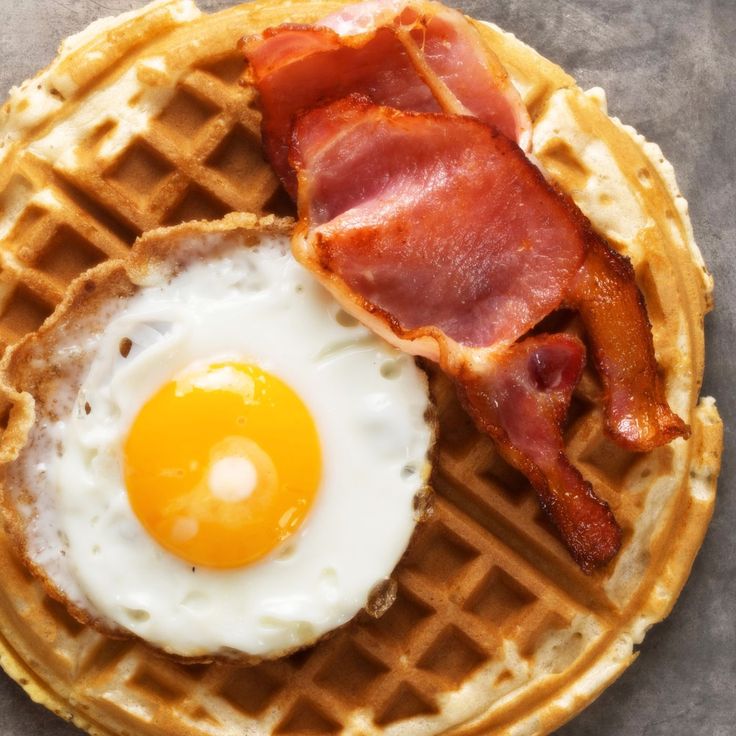 a waffle with bacon and an egg on top