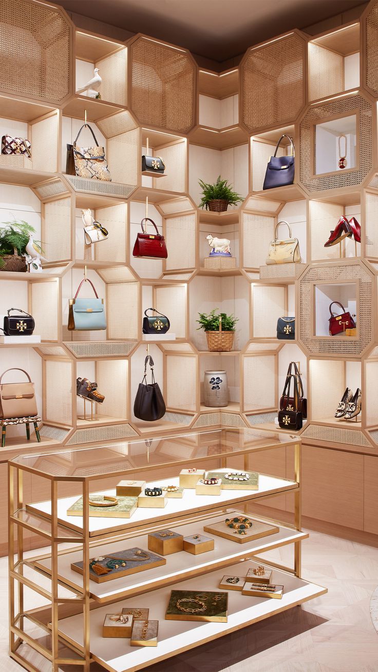 a display case filled with lots of purses and handbags on shelving units