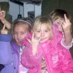 three children are posing for the camera with their hands up and fingers in the air