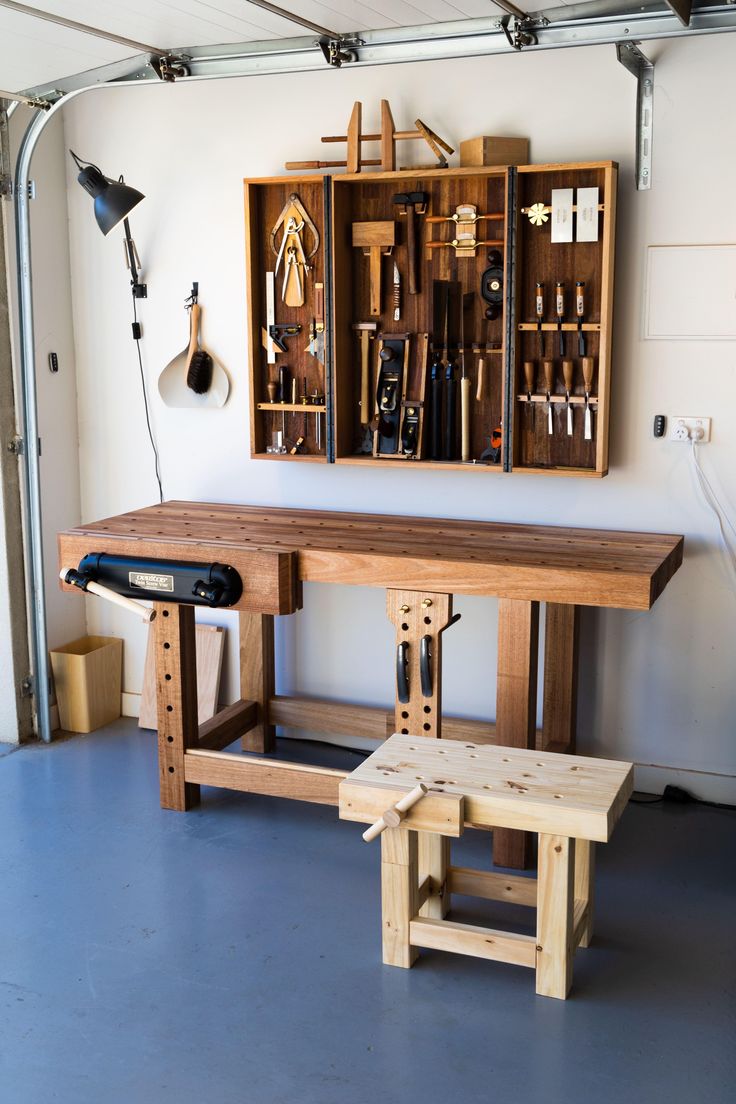 a workbench in a garage with tools hanging on the wall