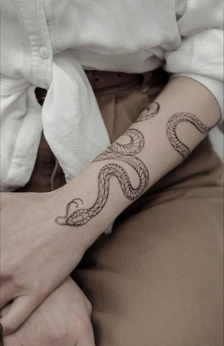 a woman's arm with a tattoo on it and a snake in the middle