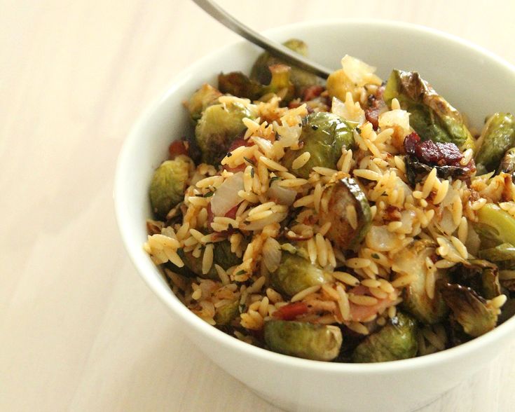 a white bowl filled with rice and brussel sprouts