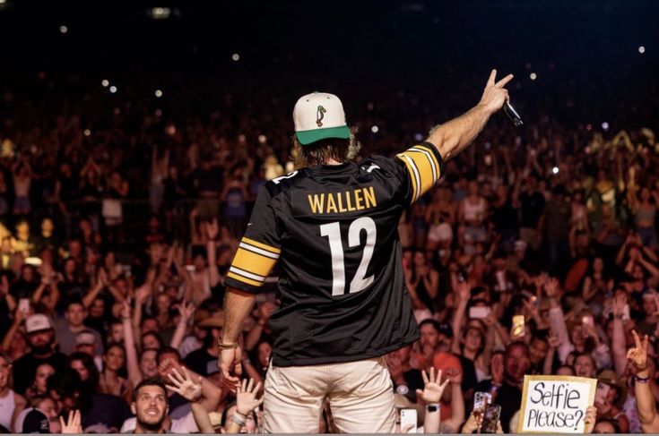 a man with his arms in the air at a football game while holding up his hands