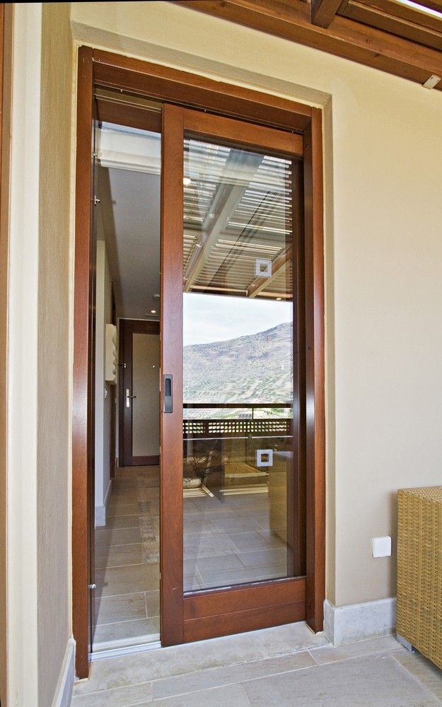 an open door leading to a balcony with mountains in the background