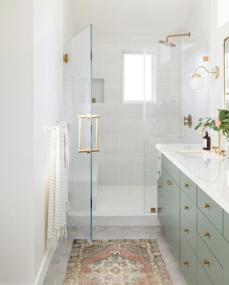 a bathroom with a rug, sink and shower stall in it's center area