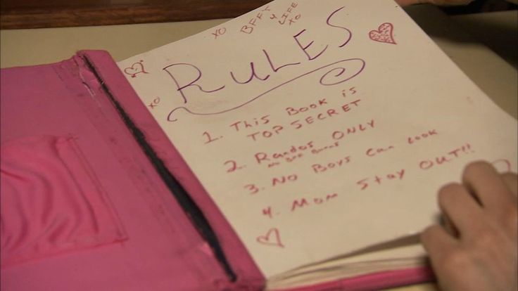 a person holding a pink book with writing on it and the words rules written in cursive ink