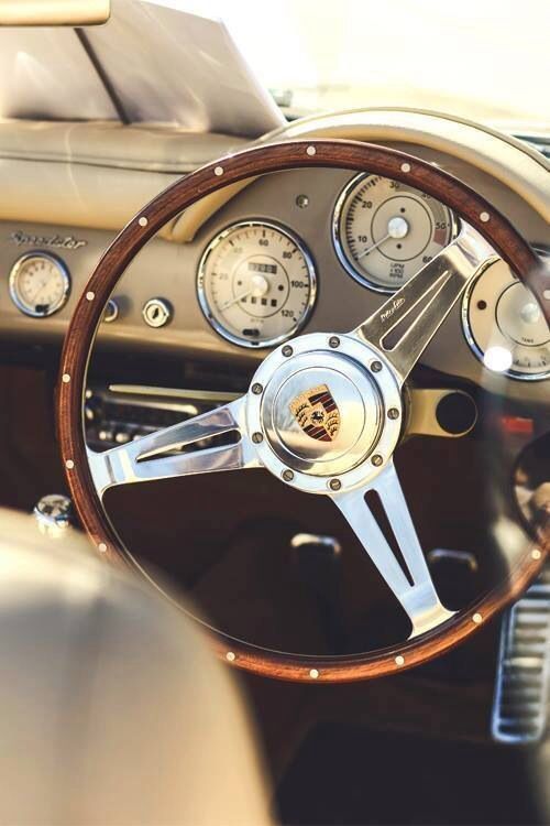 the steering wheel and dashboard of an old classic car with wood grained dash boards