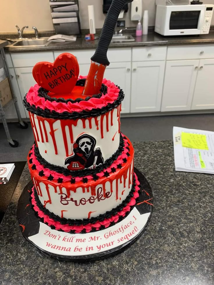 a three tiered cake with red and black icing on it's sides