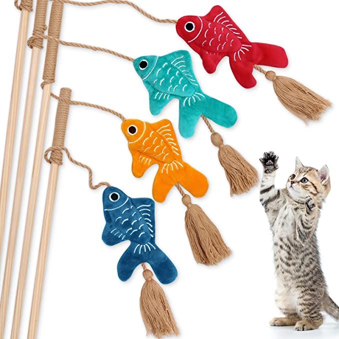 a cat standing next to a string with fish on it and another cat in the background